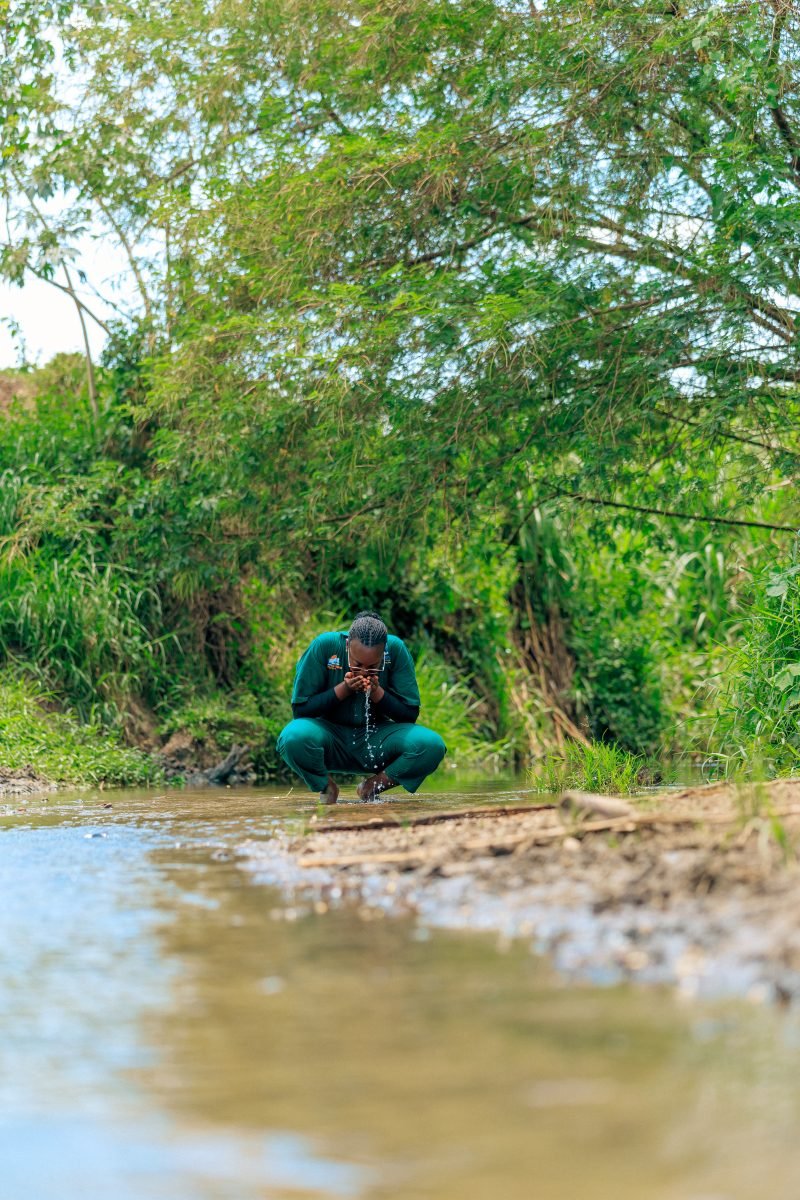 A BetterLife team member at a stream in Rukungiri