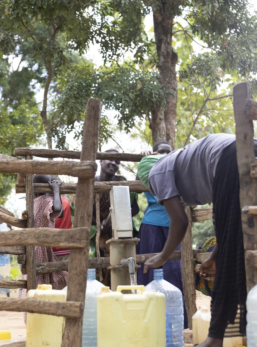 Using a hand pump at a water point in Yumbe