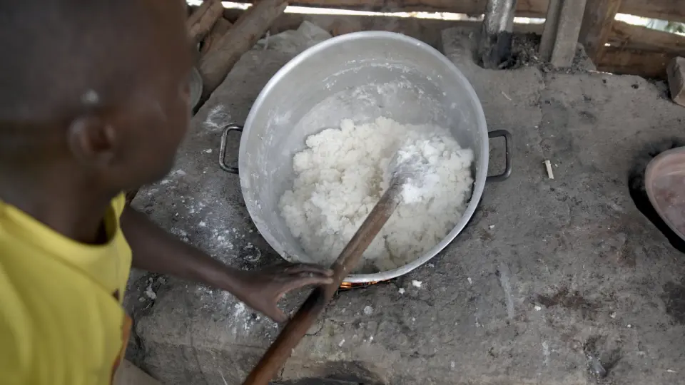 Cooks and pupils preparing and serving a meal in a school kitchen in Rukungiri
