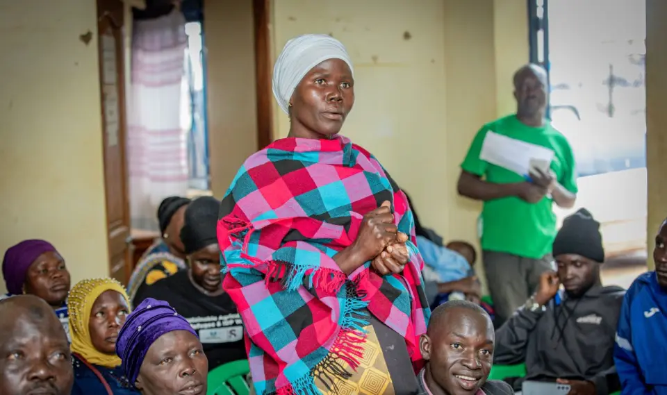 A woman stands to speak at a training session