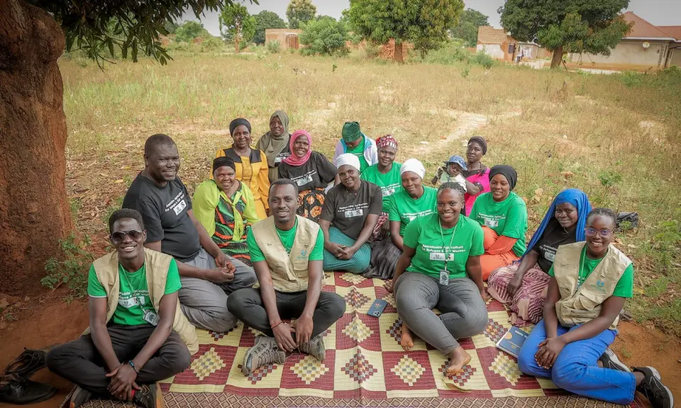 A group meeting on a mat under a tree in Yumbe
