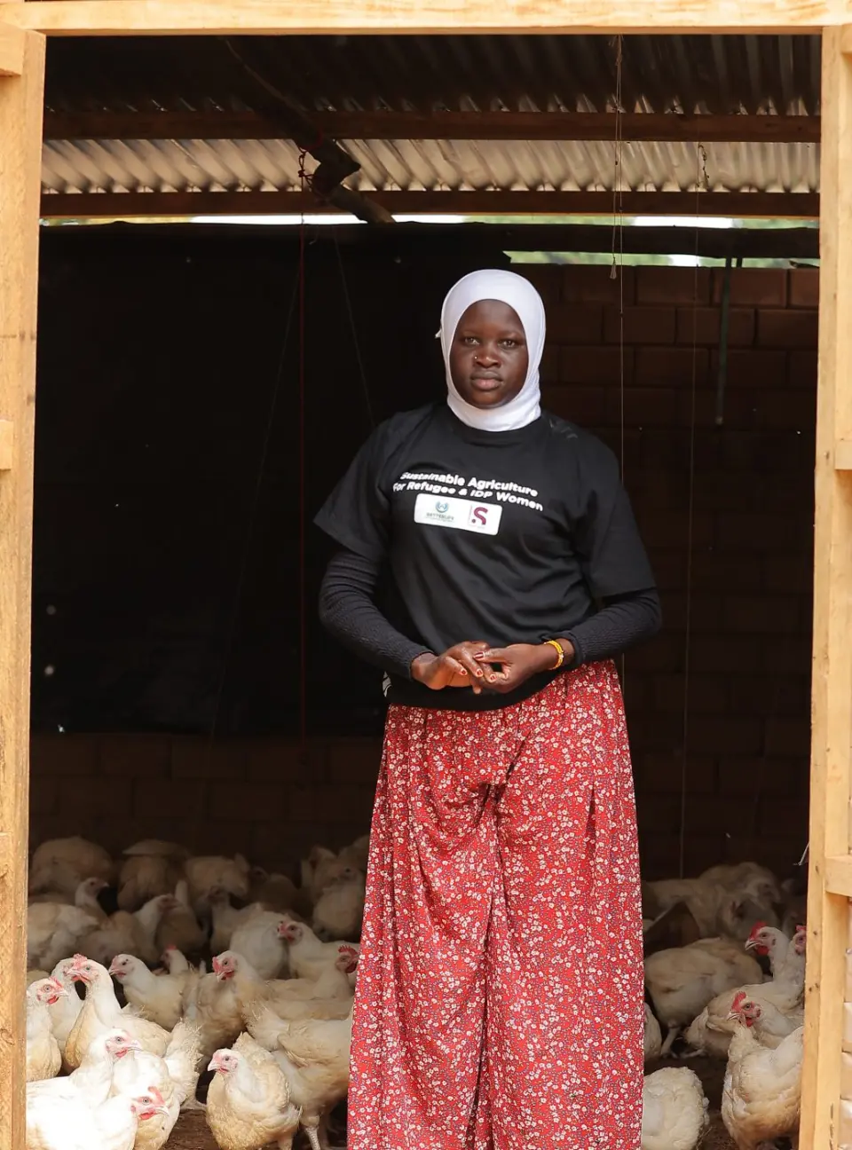 A woman standing in the doorway of her poultry house